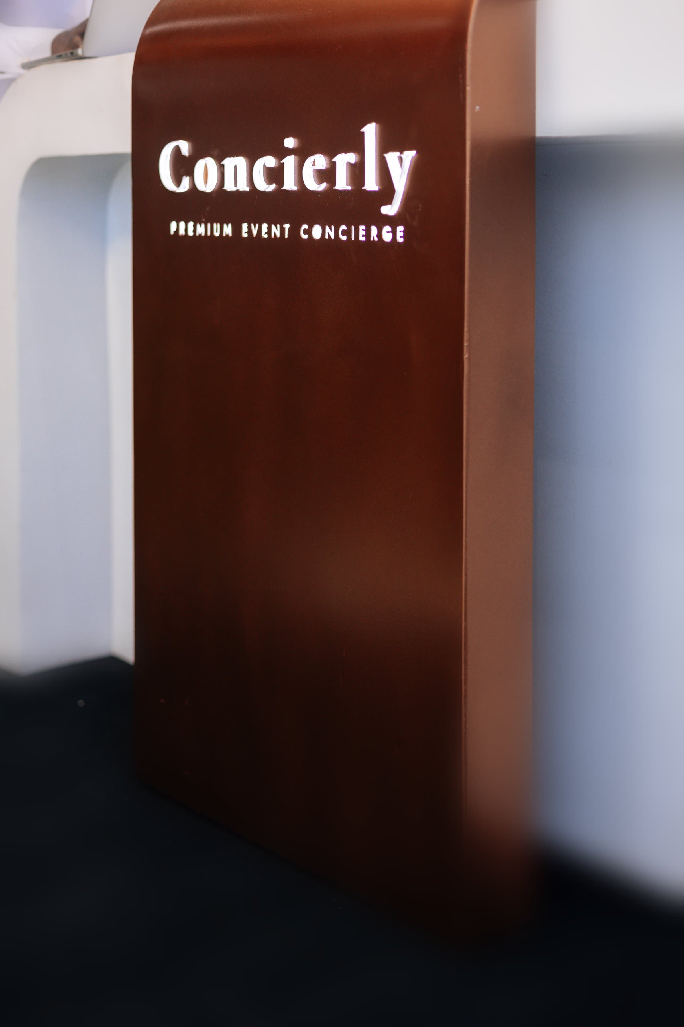 The Concierly branded kiosk, backlit and glowing at a premium event